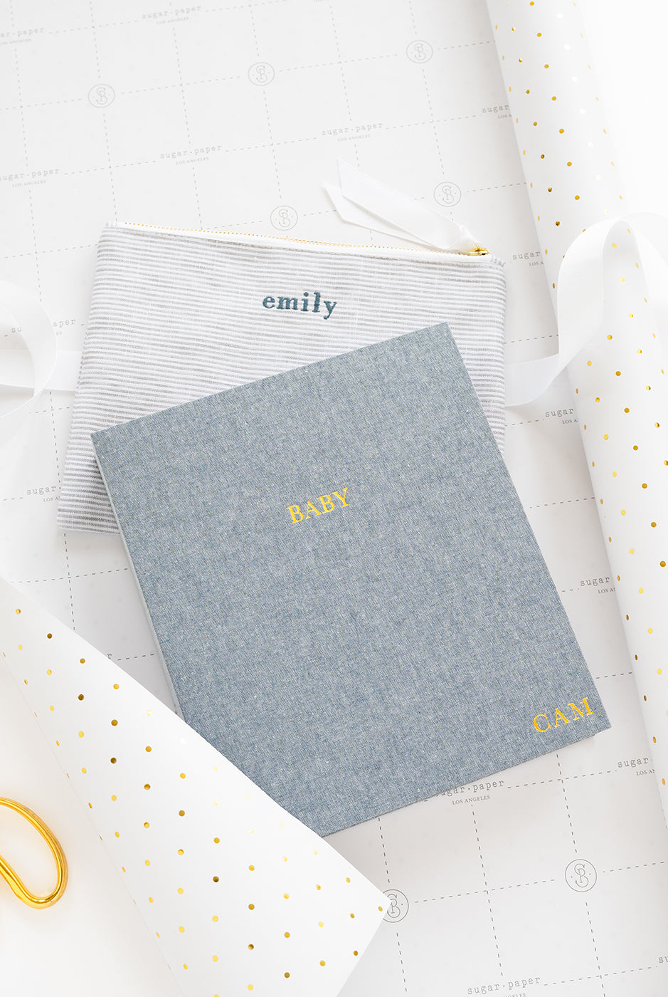 Blue baby book and pouch on wrapping paper.