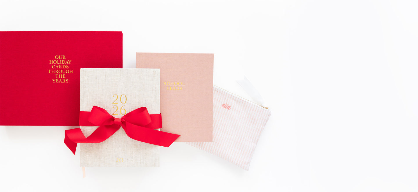 Red album, flax planner, pink keepsake book, and pink pouch on white background.