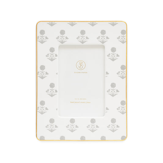 White ceramic glazed picture frame with gold border and light gray floral pattern with a 4x6 frame opening