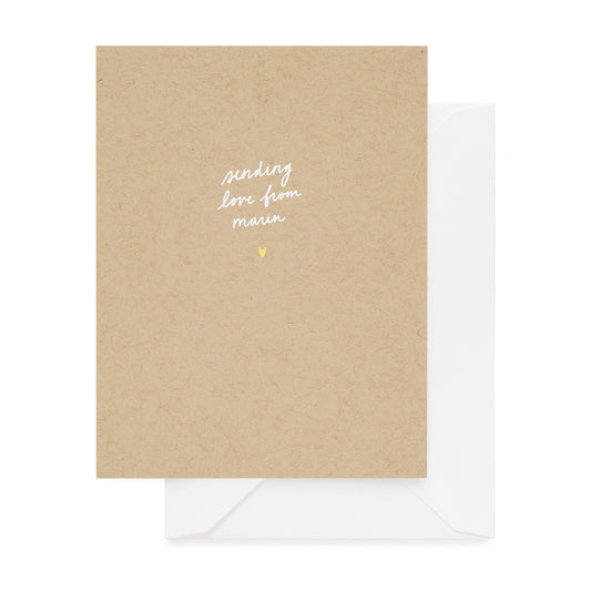 Kraft paper card with 'sending love from marin' text and a gold heart on a white background
