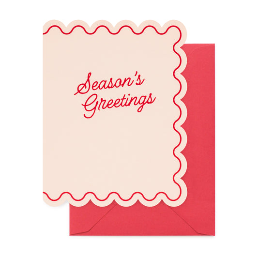 A Christmas greeting card with the words 'happy merry christmas wishes' in red script, decorated with red peppermint candies and small gold dots on pale pink paper, shown with a red envelope