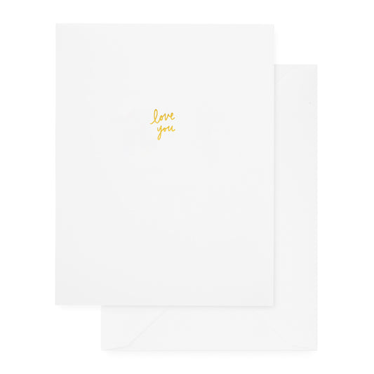white folded greeting card with gold foil love you and a white envelope