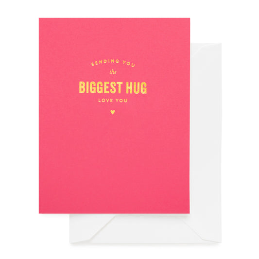 Pink card with yellow text 'Sending you the biggest hug, love you' paired with a white envelope