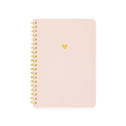 A light pink small spiral-bound notebook with a small gold heart on the front cover