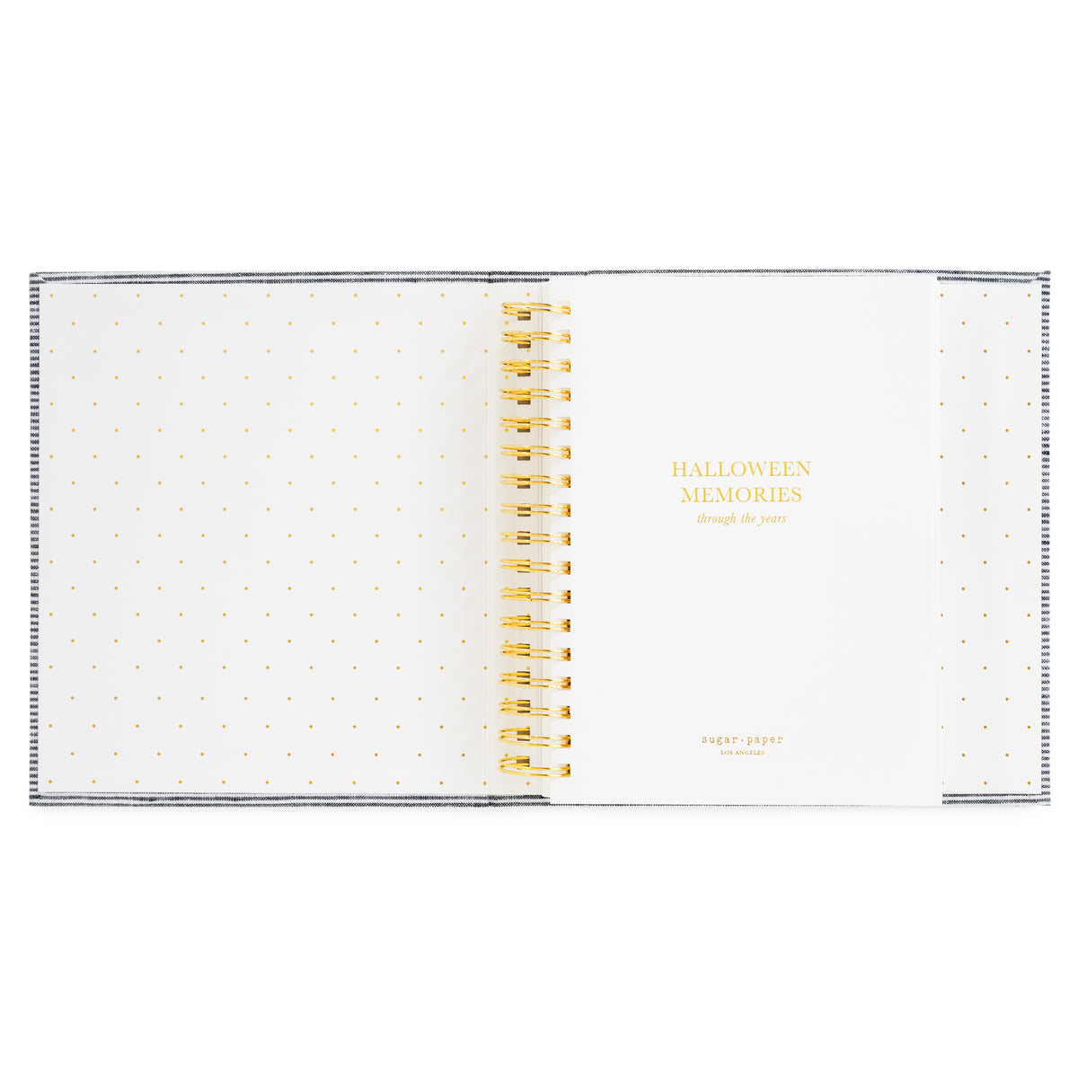 A spiral-bound memory book with white pages with gold polka dots on the pages and gold lettering that reads 'HALLOWEEN MEMORIES through the years' on the cover and gold spiral binding