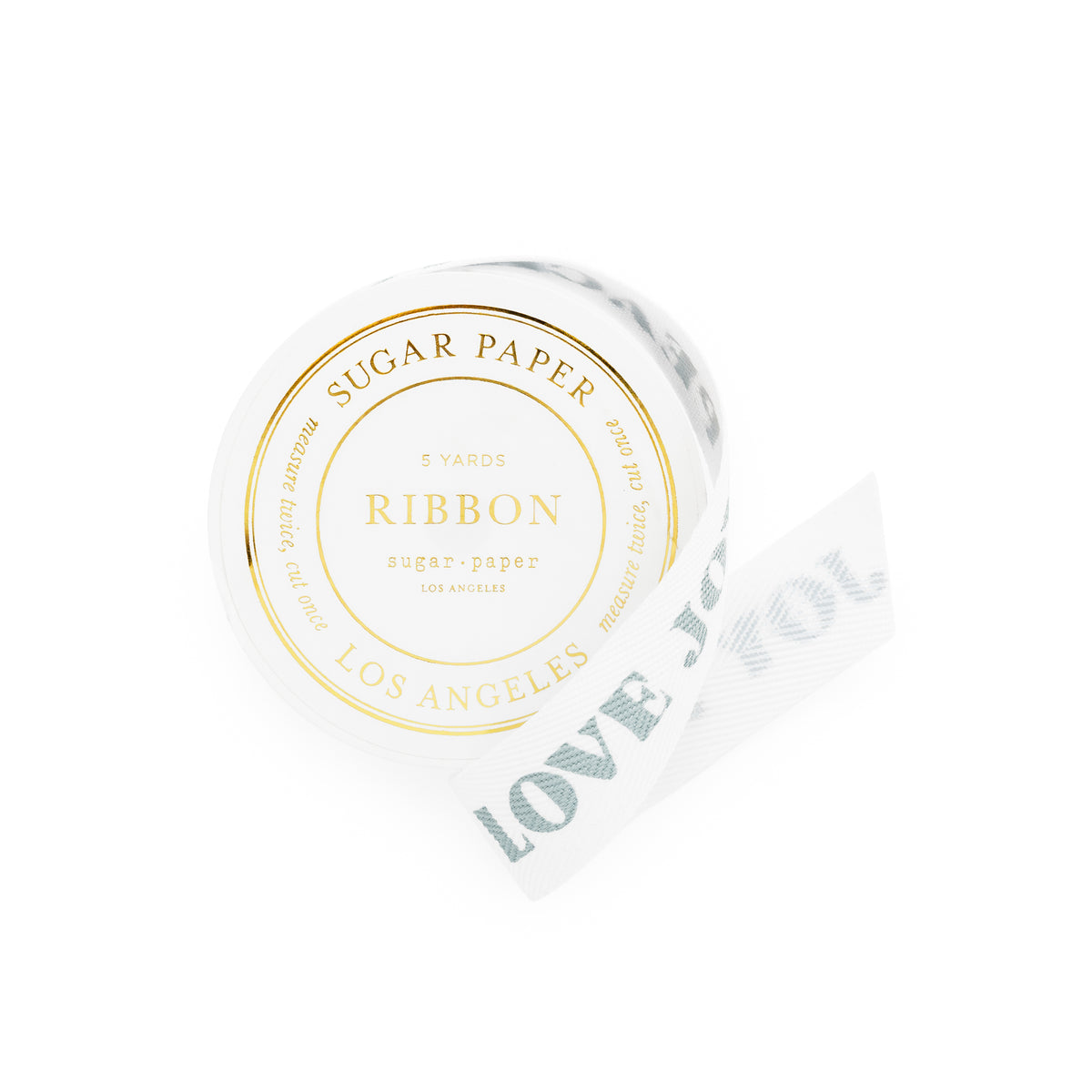 A roll of white sugar paper ribbon with blue 'peace love joy' text printed on it, shown on a clean white background. The round label on the roll reads 'SUGAR PAPER RIBBON LOS ANGELES' in gold foil