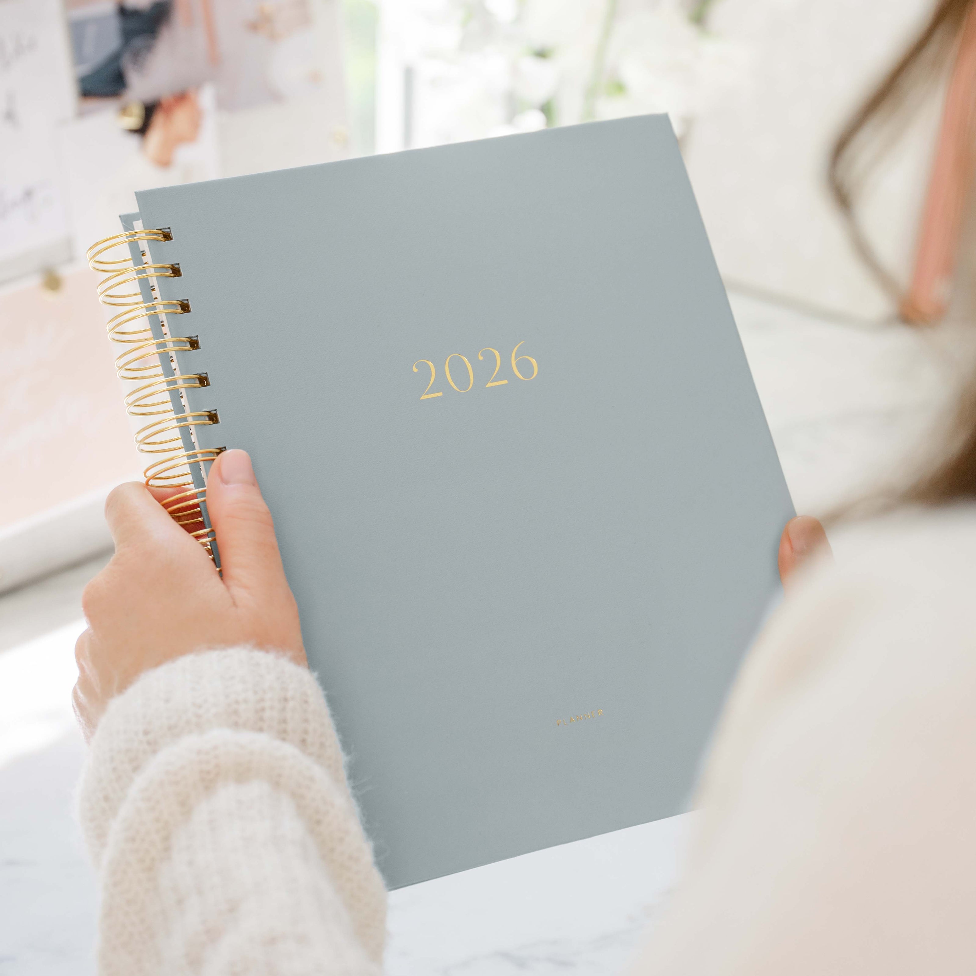 Person holding a 2026 planner with a blurred background