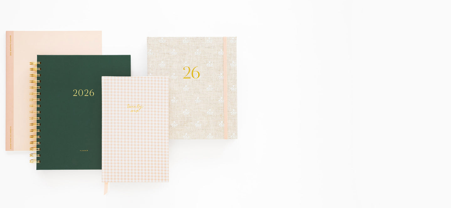 Set of four planners with different cover designs on a white background