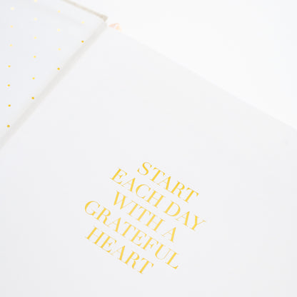 Motivational quote card with 'Start each day with a grateful heart' text in the fabric desk agenda