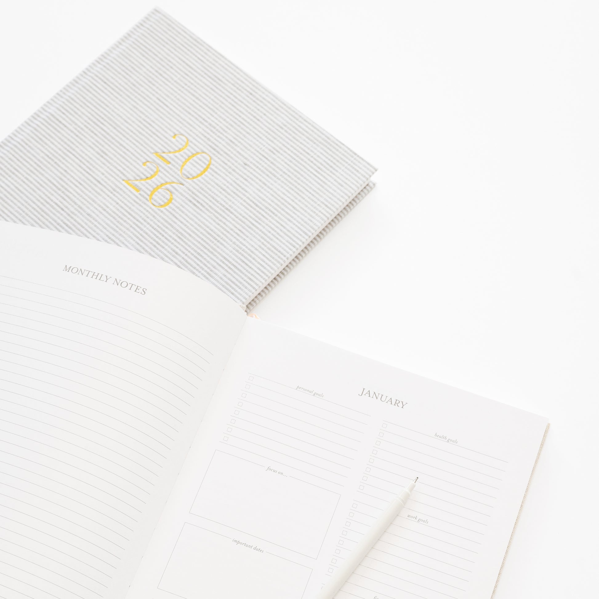 Close up of monthly notes and goals from fabric desk agenda with a grey stripe agenda cover on back