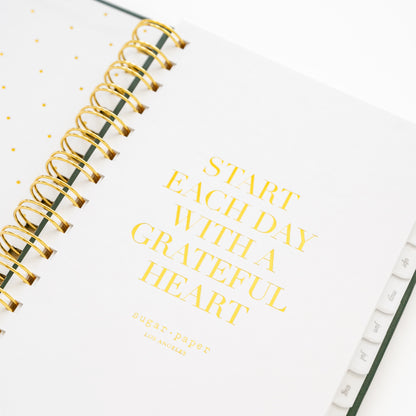 Closeup of small spiral planner quote page with 'start each day with a grateful heart'