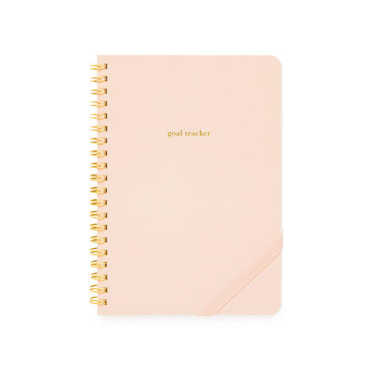 Pink goal tracker spiral notebook with gold spiral binding and a pink elastic band