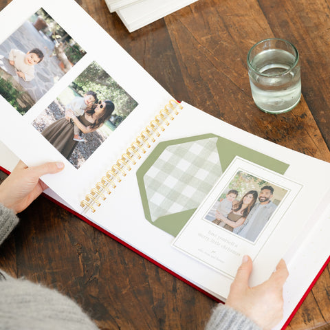 holiday card book open in hands with additional photos from family photo shoot