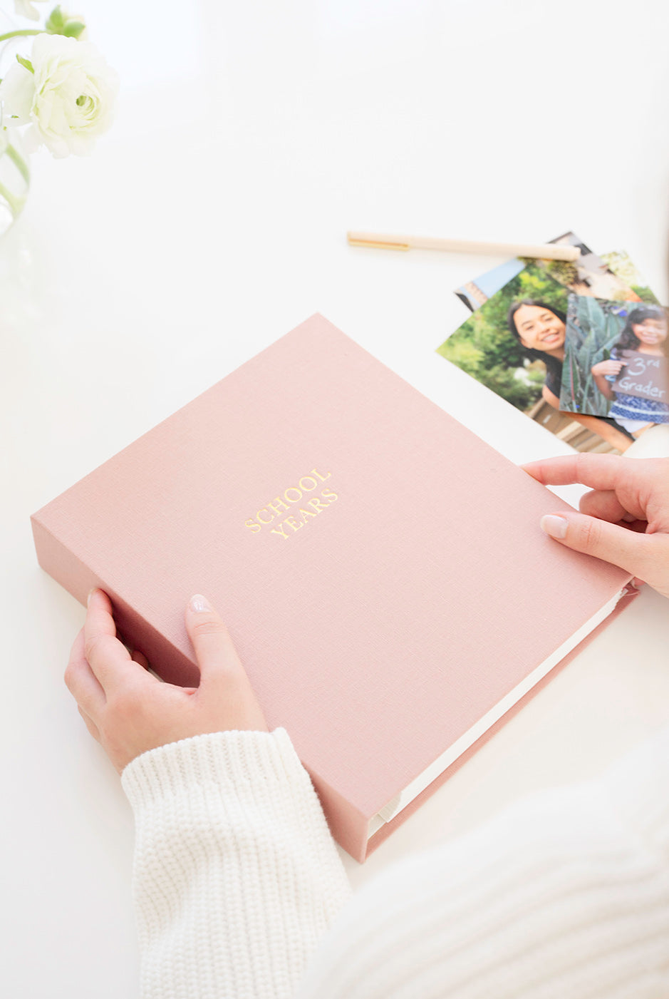 Pink keepsake book with "school years" printed on the cover.