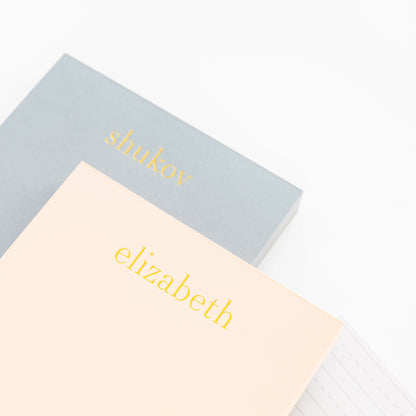 Stack of Blue and Pink Custom Notepads with Gold Foil Names