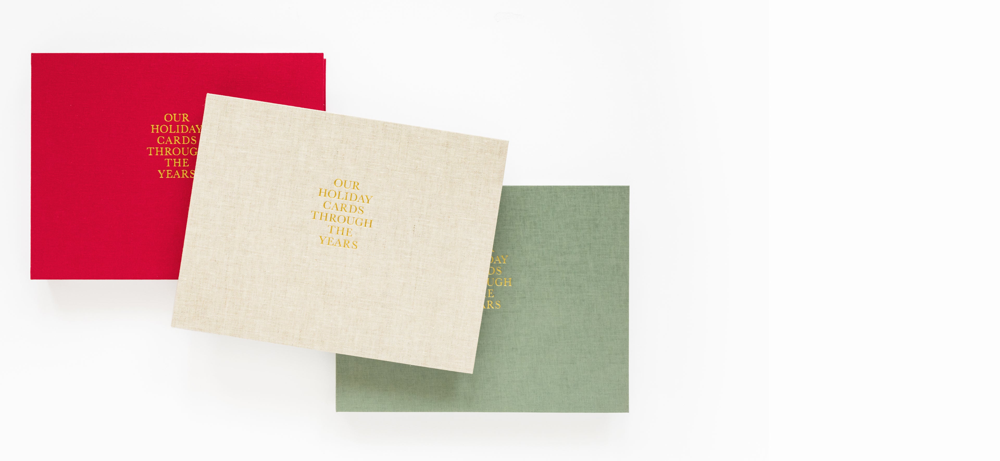 Three holiday card book in red, beige, and green with our holiday cards through the years foil stamped on the cover.