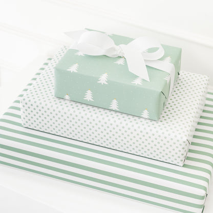 Stack of three patterned green wrapped gifts