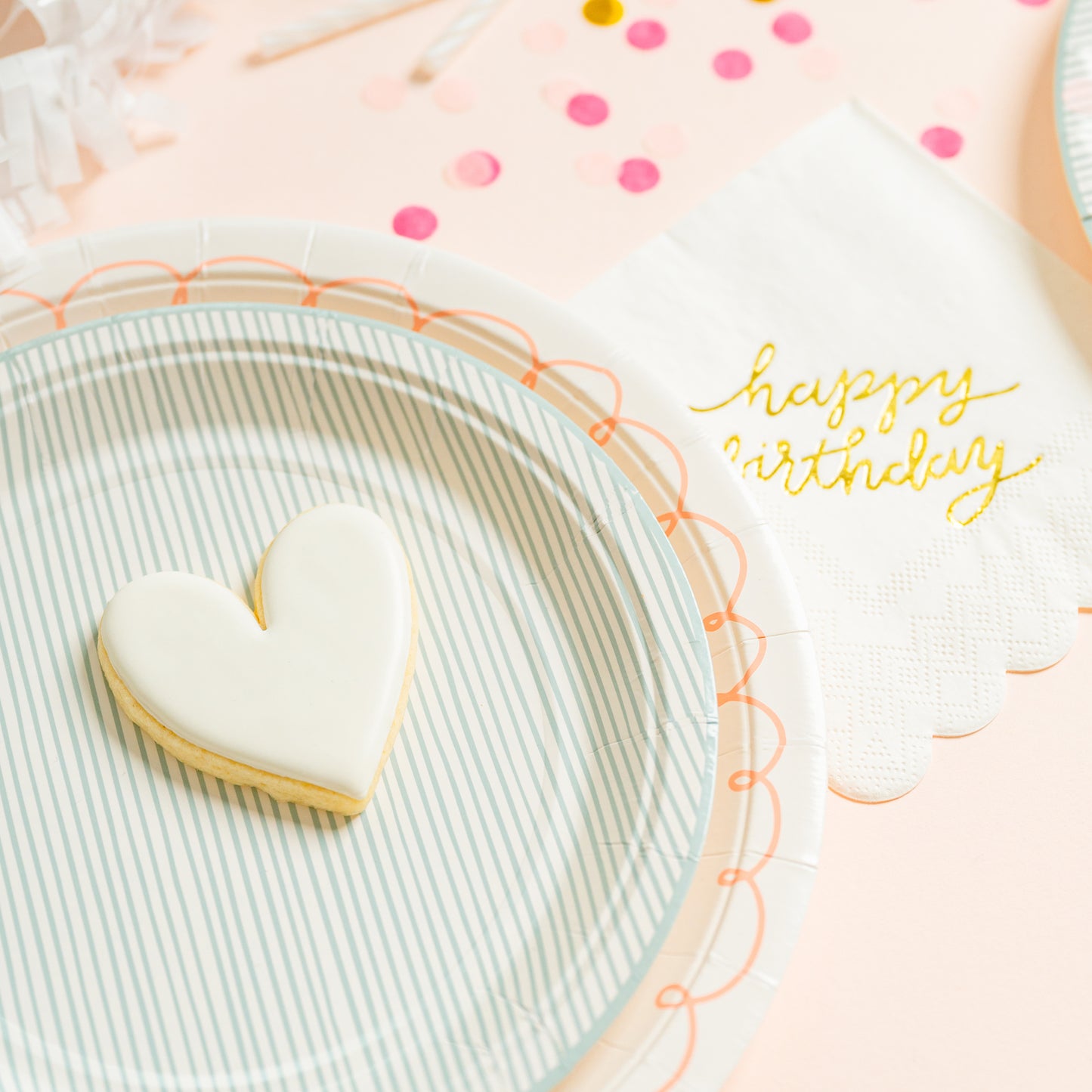 gold foil happy birthday napkin with party decoration and a heart cookie