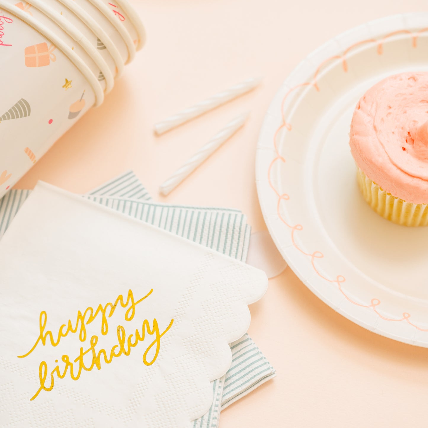 birthday party cups with napkins and pink cupcake