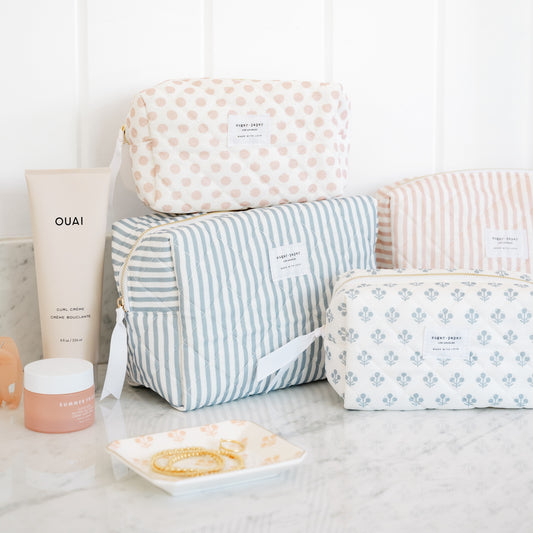 Cosmetic pouches stacked with rose floral trinket tray in bathroom