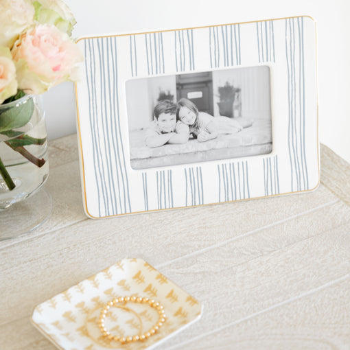 Blue and white stripe ceramic picture frame on nightstand