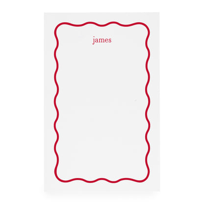 White notepad with red scallop border and 'james' text