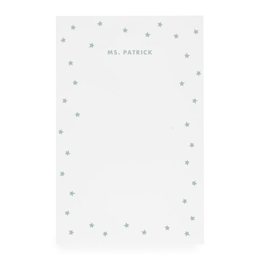 White notepad with scattered star border and 'ms. patrick' text in mint green ink