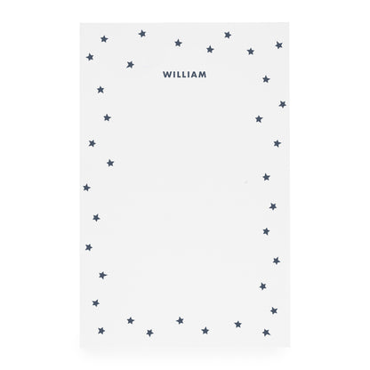 White notepad with scattered star border and 'william' in navy ink