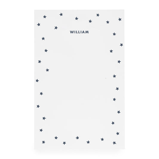 White notepad with scattered star border and 'william' in navy ink