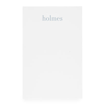 white notepad with 'holmes' text in blue ink