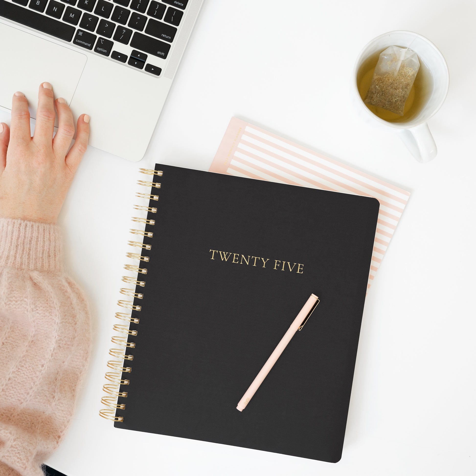 Black large weekly planner on desk with computer
