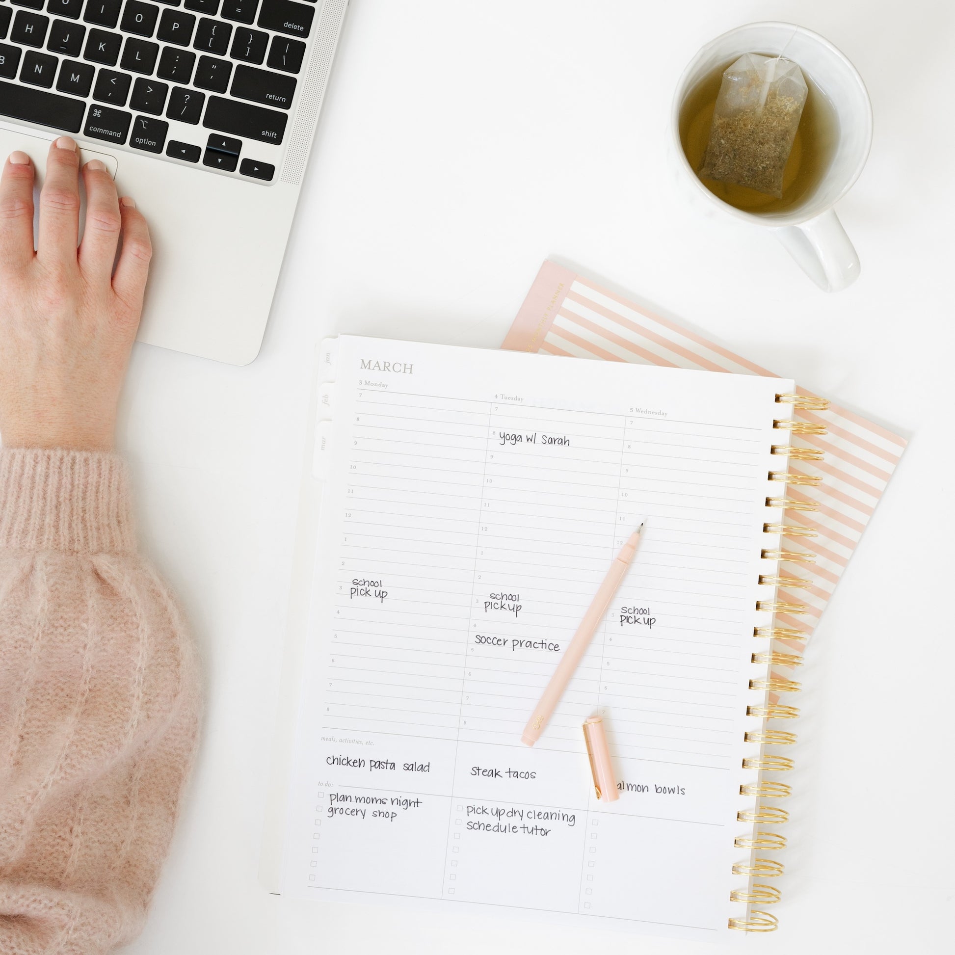 Open large weekly spiral planner with computer