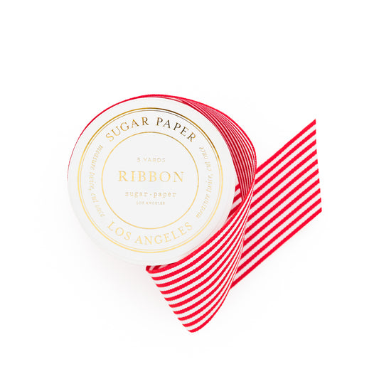 Red and white striped ribbon with 'Sugar Paper' on spool