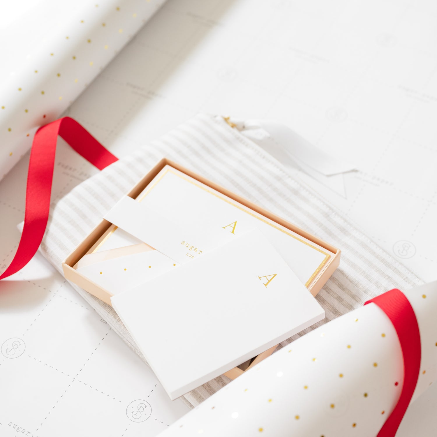 "A" initial notepad, "a" note set, flax stripe, white with gold dots and red ribbon