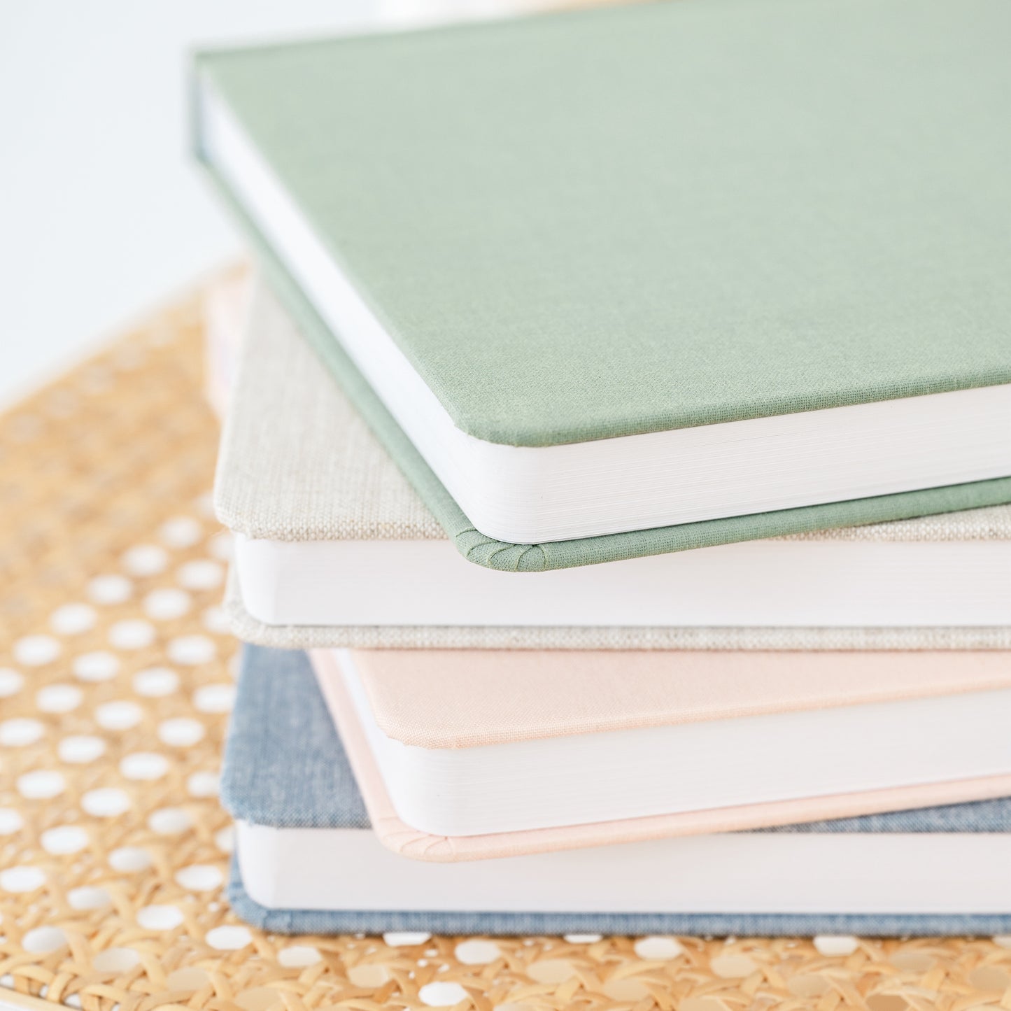 stack of undated planners in green, flax, pink, and chambray
