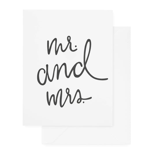 White greeting card with black script calligraphy mr. and mrs. paired with a white envelope