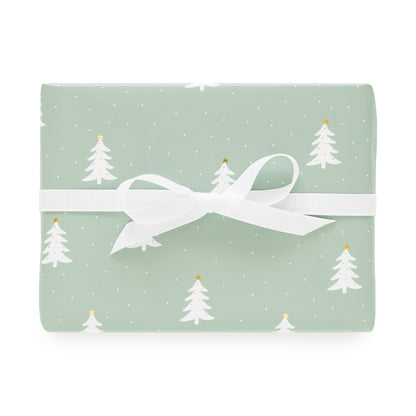 Green wrapping paper with white and gold christmas trees with a white bow