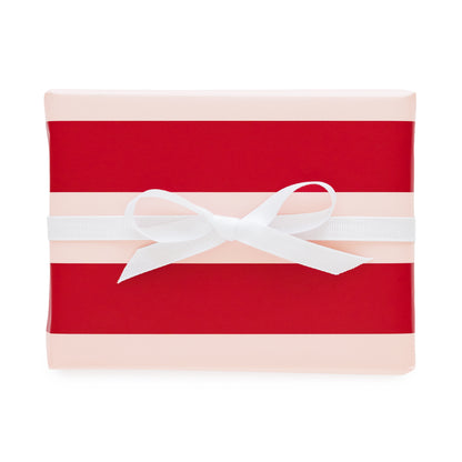 A rectangular gift box wrapped in red and pale pink striped paper with a white ribbon bow