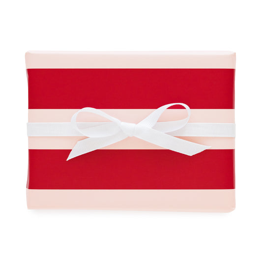 A rectangular gift box wrapped in red and pale pink striped paper with a white ribbon bow