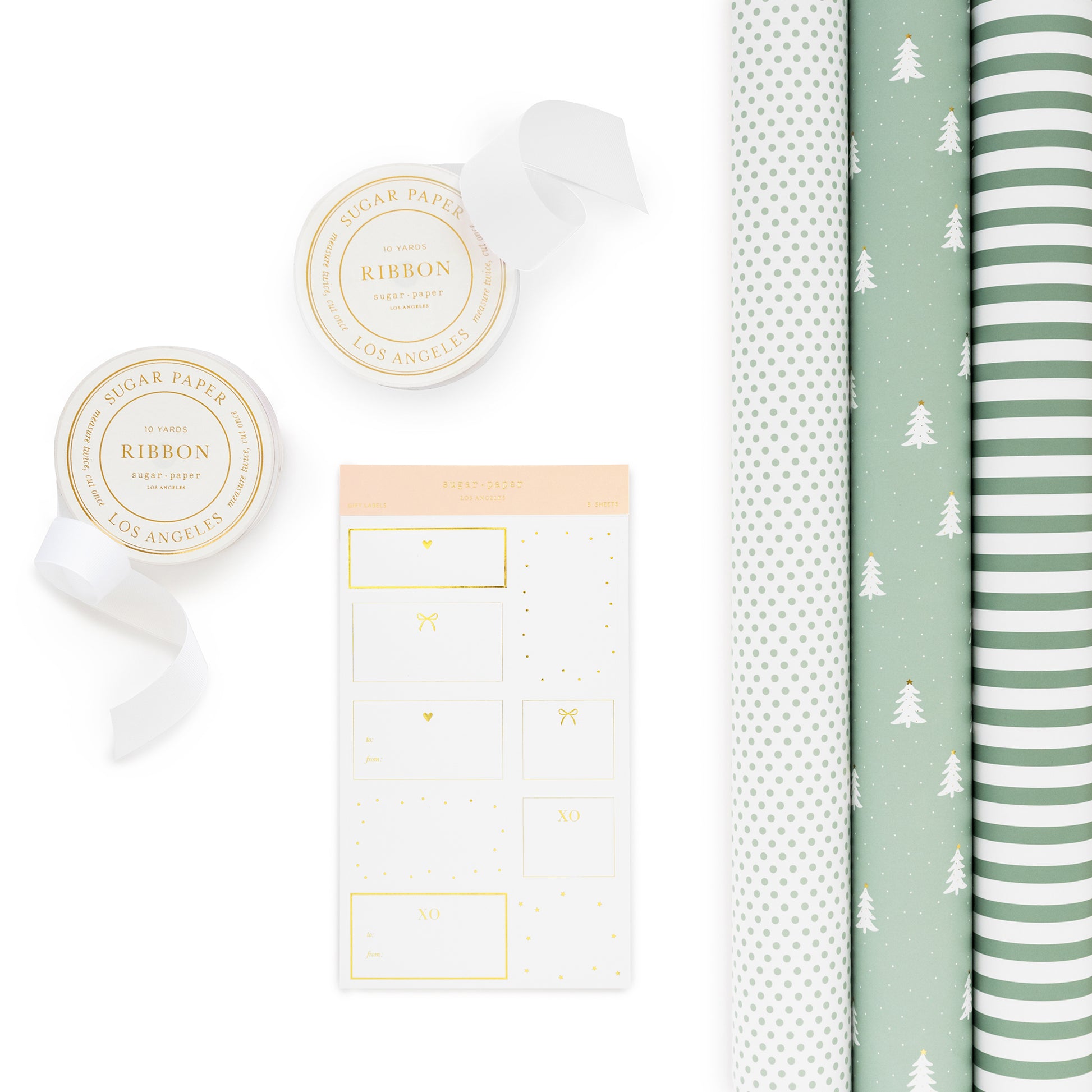 Green and white holiday wrapping kit with wrapping paper rolls, stickers and white ribbon spools