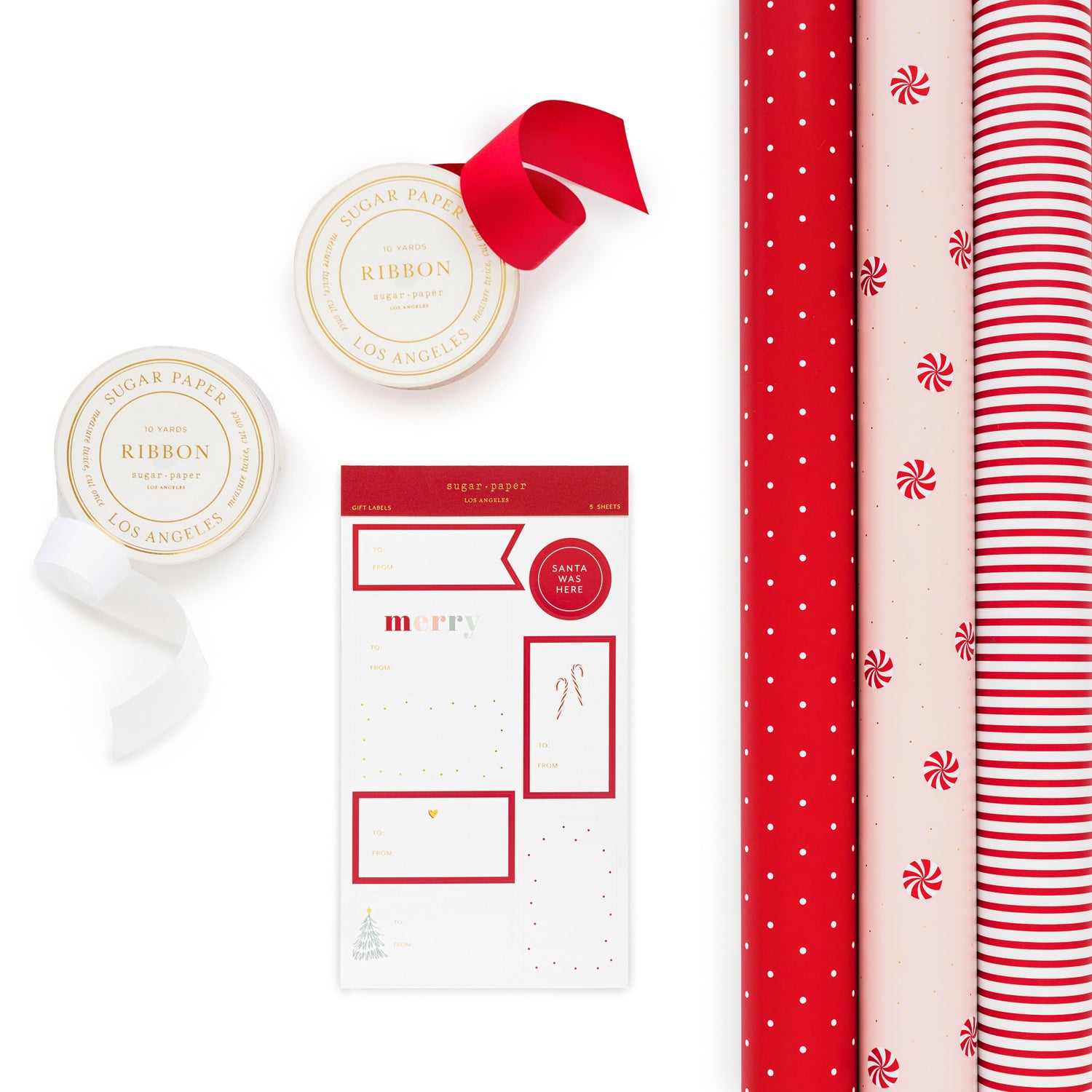 Wrapping paper kit including 3 rolls of wrap in red with white polka dots, pink with red and white peppermint candy and gold dots, and red and white stripe with rolls of red and white ribbon and holiday stickers}