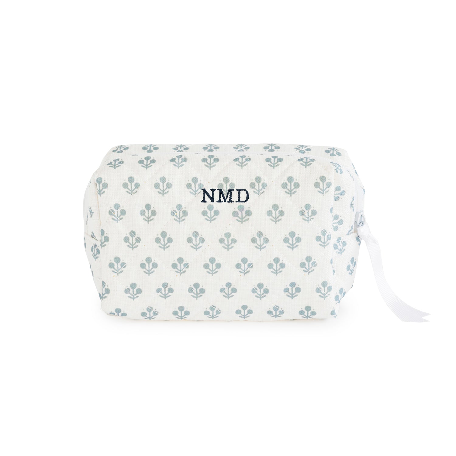 White pouch with blue floral pattern with a white ribbon zipper pull and white zipper embroidered with 'NMD' in blue thread}