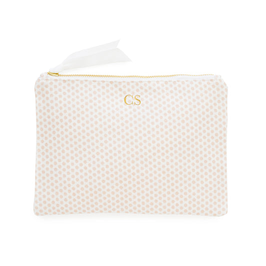 White pouch with pink polka dots and gold initials with a gold zipper and white ribbon pull