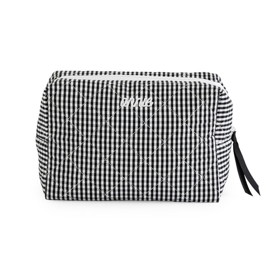 Black and white gingham cosmetic pouch with white embroidered "annie" with a black ribbon pull and white zipper