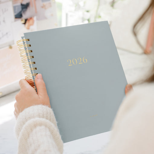 Person holding a 2026 planner with a soft focus background
