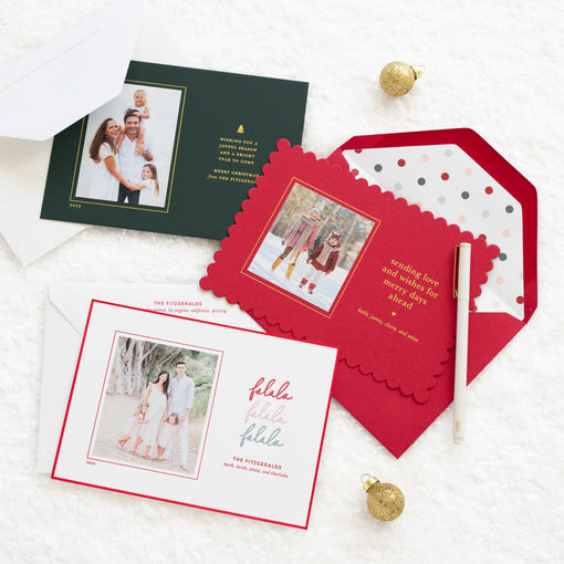 Set of holiday photo cards with envelopes on a white surface