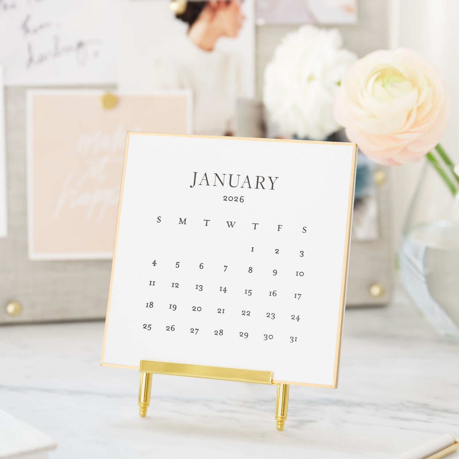 Calendar for January 2026 on a gold stand with a blurred background