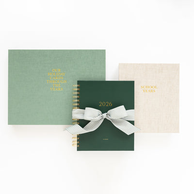 Three books with different covers and ribbons on a white background