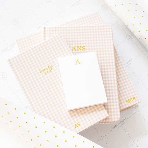 Set of gingham notebooks with gold text on a white wrap with gold dots