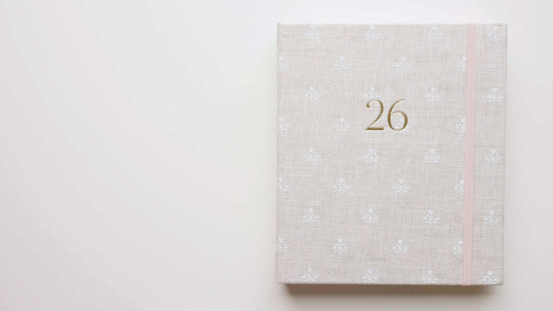 Interior of 2026 fabric bound concealed fabric planner in beige linen with white flower pattern and a pink elastic band